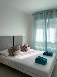 a bedroom with a large white bed with towels on it at Apartment Petrarca 13 R5331 in Pirri