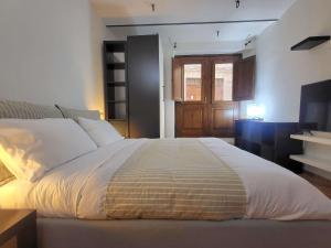 a bedroom with a large bed and a television at Appartamento davanti al Porto Romano in Bevagna