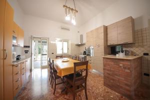 a large kitchen with a wooden table and chairs at Villa Ginevra la Dimora by Apulia Hospitality in Capitolo +31 photos