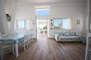 a living room with a table and a couch at Villa Ginevra la Dimora by Apulia Hospitality in Capitolo