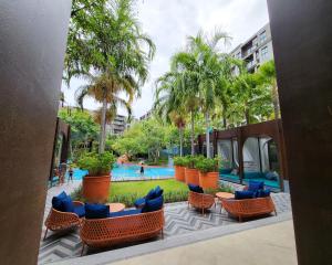 a resort with a pool and chairs and palm trees at La Habana HuaHin by ABCD in Hua Hin
