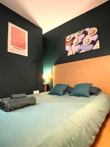 a bedroom with a large bed with blue pillows at Le Roland-Garros in Chalon-sur-Saône