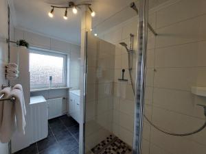 een badkamer met een douche met een glazen deur bij Fewo Flutbarke in Wilhelmshaven +17 foto's