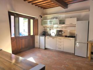 a kitchen with white appliances and a wooden door at Appartamento davanti al Porto Romano in Bevagna