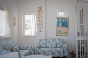 a living room with a couch and a chair at Villa Ginevra la Dimora by Apulia Hospitality in Capitolo