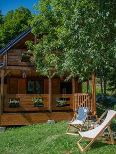 dos sillas sentadas frente a una cabaña de madera en Green Cottage Njegoš 