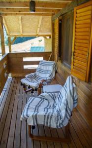 twee stoelen op een veranda van een hut bij Green Cottage Njegoš 