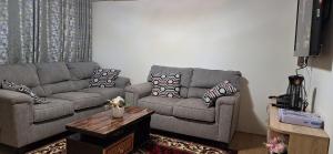 a living room with two couches and a coffee table at A Cozy Luxury Hideout in North Ridge, Accra, 1BDRM - 2BDRM, 15 mins from Airport in Accra