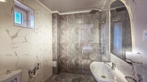 a bathroom with a shower and a sink and a tub at Hotel Bankir Khiva in Khiva