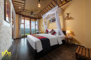 a bedroom with a white bed and a window at Hanasa Pu Luong Resort in Pu Luong