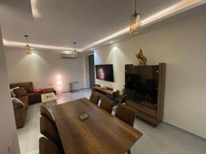 een woonkamer met een houten tafel en een televisie bij 4S private room in a shared appartment in Caïro