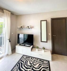 ein Wohnzimmer mit einem TV und einem Spiegel in der Unterkunft Nova Beach Apartment 41 in Gran Alacant