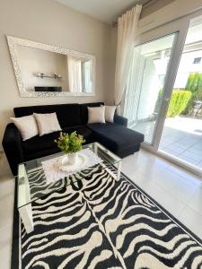 a living room with a black couch and a zebra rug at Nova Beach Apartment 41 in Gran Alacant