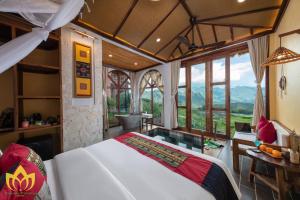 a bedroom with a bed in a room with windows at Hanasa Pu Luong Resort in Pu Luong