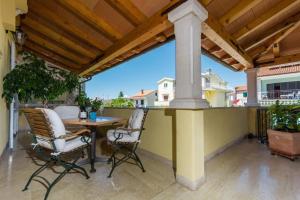a patio with a table and chairs on a balcony at Guesthouse Casa Nova in Poreč