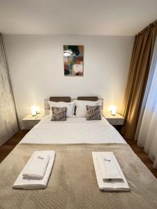 1 dormitorio con 1 cama grande y 2 toallas. en Deluxe Cozy Apartments - Coresi Mall #Brasov en Brasov