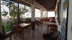 an empty restaurant with wooden tables and chairs at Pousada e Pizzaria Sol e Alegria in Fortaleza