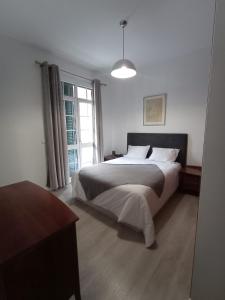 a bedroom with a large bed and a window at Friendly house in Funchal