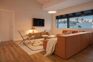 a bedroom with a bed and a living room at Villa Tropico - Design house with pool in Corralejo in Corralejo
