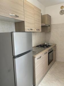 uma cozinha com um frigorífico branco e armários de madeira em Appartamento Ladispoli em Ladispoli