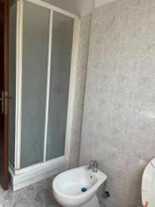 uma casa de banho com um chuveiro, um WC e um lavatório. em Appartamento Ladispoli em Ladispoli