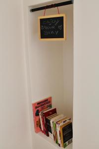a shelf with books and a chalkboard on a wall at Kiko's Lodge - Historical apartment in Como in Como