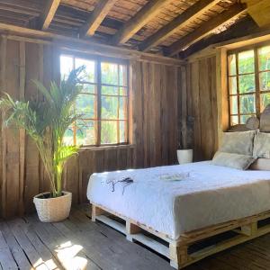 1 dormitorio con 1 cama en una habitación con paredes de madera en Punta Arena EcoHostal and EcoFit – Your Eco-Friendly Oasis 01 en Cartagena de Indias