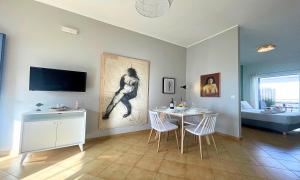 salon ze stołem i telewizorem na ścianie w obiekcie Art Apartment w mieście Palaiochóra
