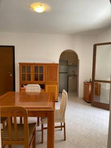 uma sala de jantar com mesa e cadeiras e uma cozinha em Appartamento Ladispoli em Ladispoli