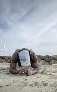 um homem deitado na areia na praia em Punta Arena EcoHostal and EcoFit – Your Eco-Friendly Oasis 01 em Cartagena das Índias