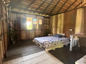 a bedroom with a bed and a table and a window at Punta Arena EcoHostal and EcoFit – Your Eco-Friendly Oasis 01 in Cartagena de Indias