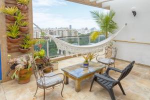 Cette chambre dispose d'un balcon avec un hamac et des plantes. dans l'établissement Cobertura duplex com vista panoramica na Gavea, à Rio de Janeiro