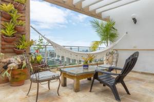 a room with a table and chairs and a hammock at Cobertura duplex com vista panoramica na Gavea in Rio de Janeiro