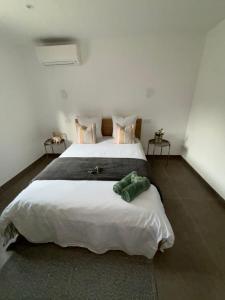1 dormitorio con 1 cama blanca grande y 2 mesas en Les Oliviers, en Arles