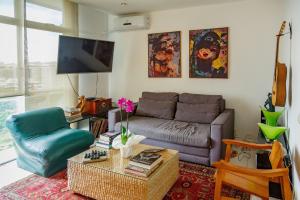 a living room with a couch and a chair at Cobertura duplex com vista panoramica na Gavea in Rio de Janeiro