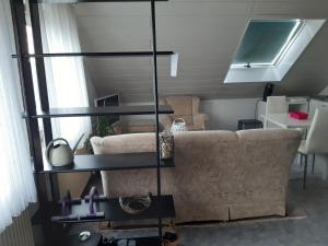a living room with a couch and glass shelves at Ruhiges Einzimmer-Apartment in Backnang