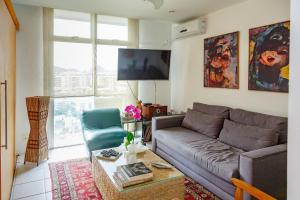 sala de estar con sofá y silla en Cobertura duplex com vista panoramica na Gavea en Río de Janeiro