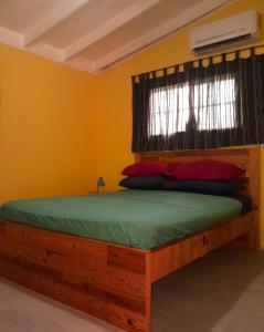 a bedroom with a wooden bed with a window at Hopi Cadushi Apartment in Santa Cruz