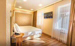 a bedroom with a bed and a table and a window at Hotel Bankir Khiva in Khiva
