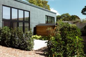 a brick house with large windows and bushes at B en B De Jufferswaard in Renkum