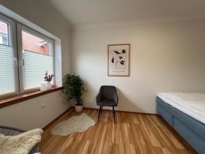 una camera da letto con un letto e una sedia di Ferienwohnung Cléo - 5 Minuten vom Schloss Dankern entfernt a Haren