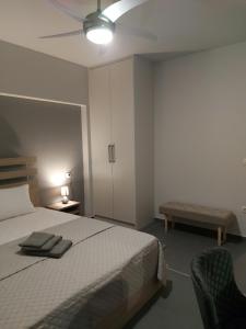 Square Apartments في تريكالا: غرفة نوم بسرير ومروحة سقف