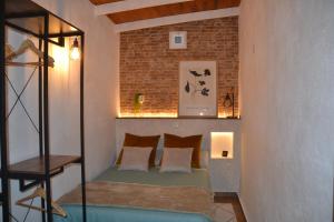 een kleine slaapkamer met een bed en een bakstenen muur bij Suite 85, Villa Boutique privada con piscina in Icod de los Vinos