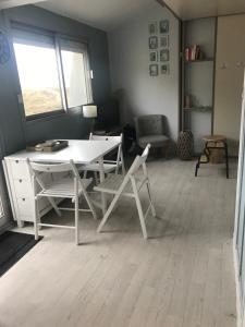 a living room with a white table and chairs at Studio Le Sandettie à 50m de la plage! in Fort-Mahon-Plage