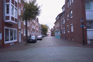 une rue vide avec des voitures garées sur le côté d'un bâtiment dans l'établissement Modernes Apartment in der Altstadt , kostenlose Parkplätze in der Nähe, à Emden