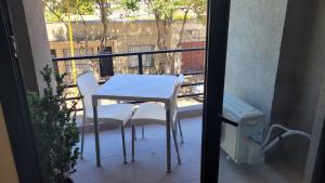 - Balcón con mesa y 2 sillas blancas en Depto Edificio Vias Gualeguaychú, excelente en Gualeguaychú