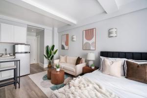 a white bedroom with a bed and a kitchen at 73-1204 New Studio UWS Doorman Gym in New York