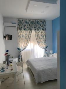 Schlafzimmer mit einem Bett, einem Tisch und einem Fenster in der Unterkunft Alex's Home in Portici