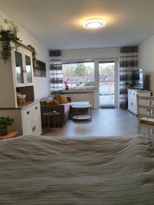 a room with a bed and a living room with a couch at Apartment am Park 2 in Duisburg