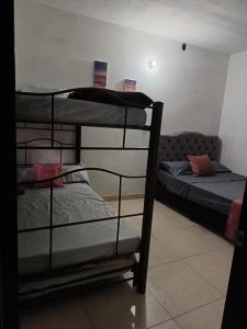 een kamer met 2 stapelbedden en een bank bij Hotel Policarpa in Guaduas